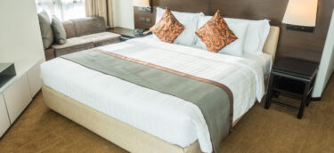 White pillow on bed decoration in bedroom interior with table light lamp